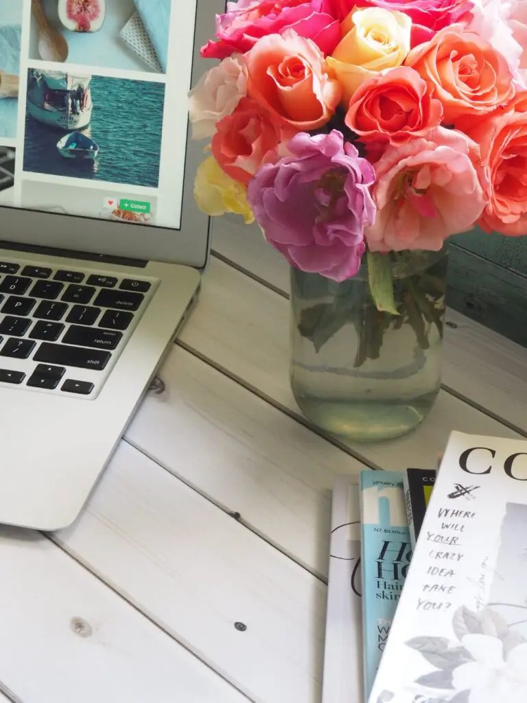 Kalanchoe Blossfeldiana displayed in a clear glass vase beside a laptop