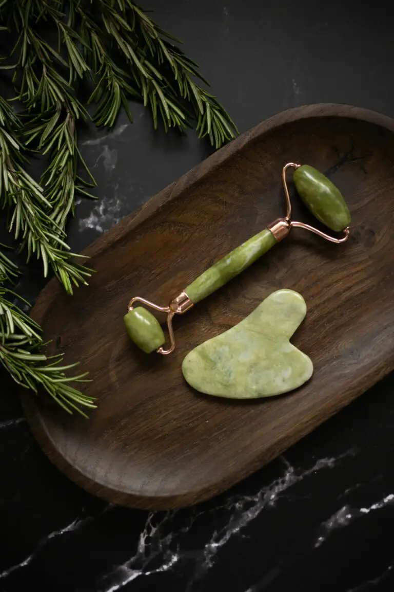 Jade roller and Gua Sha massage tool on wooden plate symbolizing the beauty of Jade Rose Sempervivum