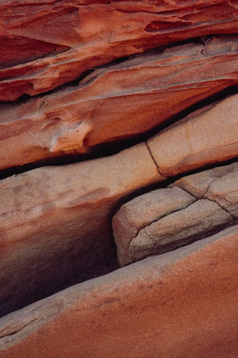 Stratigraphic layers of red and orange sandstone, illustrating how do sedimentary rock layers form