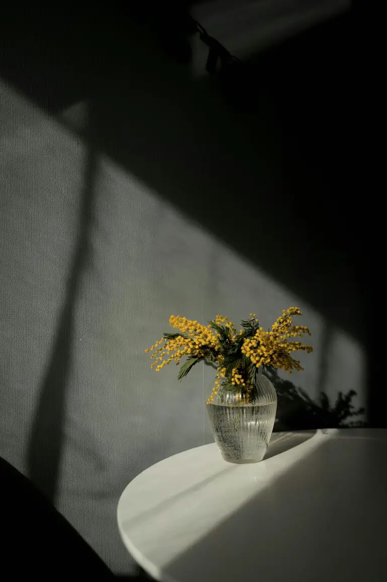 A vase of sedum flowers on a table