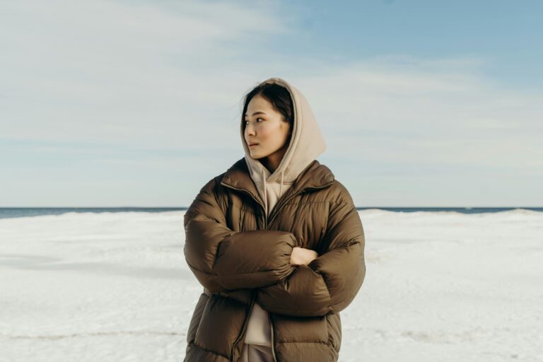 What does sedum look like in winter - A Woman in Brown Puffer Jacket Standing on a Snow Covered Ground